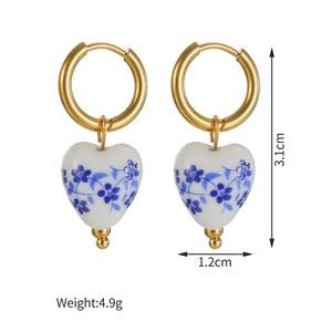 Detail view of heart-shaped blue and white ceramic earrings with dimensions 3.1cm x 1.2cm