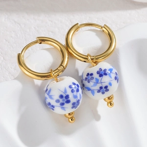 Detail of blue and white porcelain ceramic bead earrings with golden circular hoops
