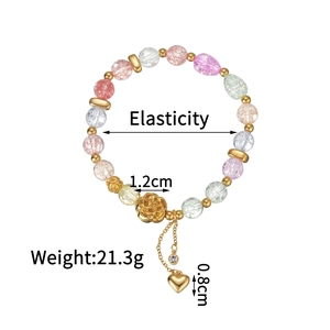 Detail of colorful crystal bead bracelet featuring golden rose and heart charm with dimensions