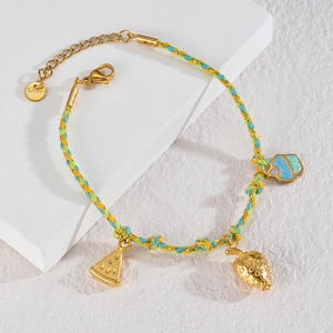Detail of woven rope bracelet featuring golden fruit charms and stainless steel lobster clasp