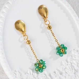 Detailed macro view of long drop earrings with gold shell studs and green beaded flowers