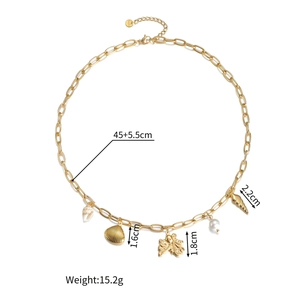 Detailweergave van 18K vergulde marine bedeltjes met schelp en parel aan een schakelketting