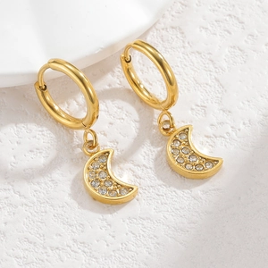 Close-up of golden hoop earrings with sparkling crescent moon pendants and rhinestones