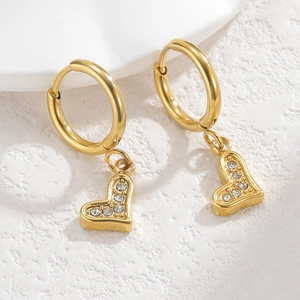 Detail of 18K gold crown heart earrings with sparkling small zircons on stone surface