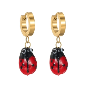 Détail des boucles d'oreilles coccinelle dorées avec émail rouge et noir éclatant