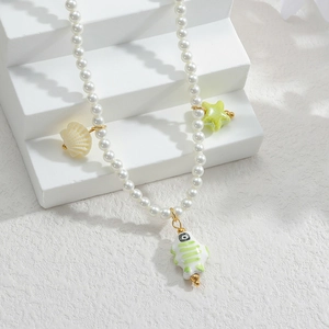 Détail du collier de perles avec pendentifs en céramique tulipe et maillons dorés