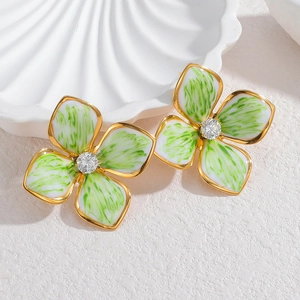 Détail des boucles d'oreilles fleurs en émail avec texture brossée verte et bordure dorée