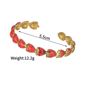 Bracelet jonc ouvert doré orné de breloques fraises en émail rouge et feuilles vertes