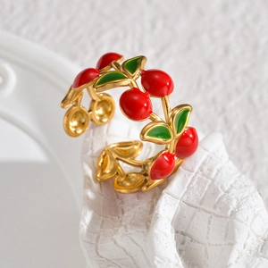 Macro shot of an adjustable gold ring featuring red cherry enamel patterns on a white base