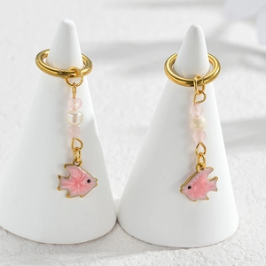 Detail of gold fish earrings with white freshwater pearl and pink gemstone charms