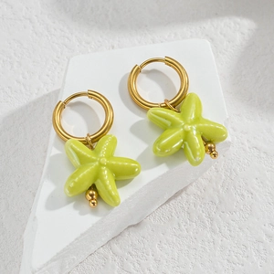 Détail de boucles d'oreilles étoile de mer jaune-vert avec anneaux dorés et émail céramique