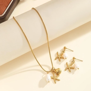 Detailed close-up of golden starfish, seashell, and pearl charms on a delicate necklace