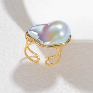 Macro detail of 18k gold stainless steel open ring with blue baroque pearl accents