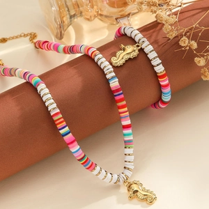 Détail de l'ensemble bijoux en perles heishi colorées avec pendentif hippocampe doré