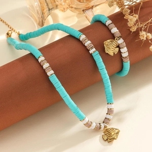 Détail du pendentif poisson or 18 carats et du collier de perles Heishi turquoise