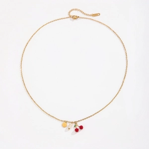 Gold cherry pendant necklace with red fruit charms and white beads on a clean white backdrop