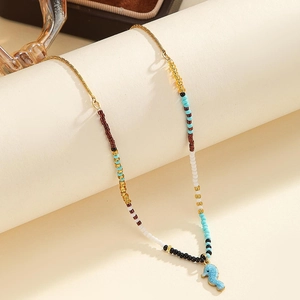 Bohemian colorful beaded necklace featuring a gold-edged blue seahorse charm and metal chain