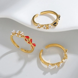 Three-piece set of adjustable gold bow rings with colorful enamel and pearl accents