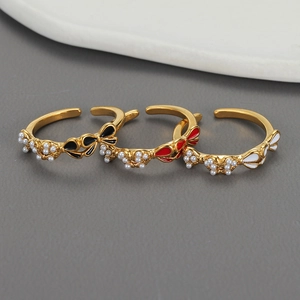 Three-piece gold adjustable ring set with pearl bows and black red white enamel finish