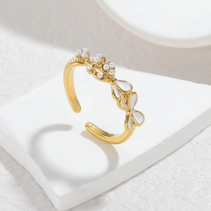 Macro detail of adjustable gold plated ring featuring white enamel butterfly and pearls
