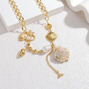 Gold stainless steel ocean necklace with shell starfish and pearl charms on white blocks