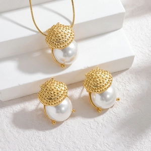 Set collana e orecchini di perle dorate vintage su espositori geometrici