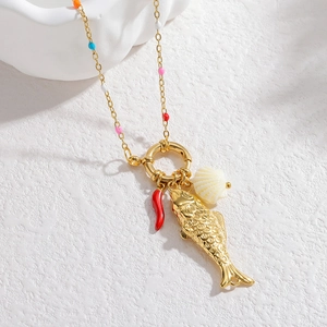 Detail of a gold necklace featuring fish, red chili, and seashell charms with beads
