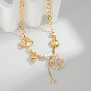 Detail of gold ocean necklace featuring shells, starfish with pearl, and baroque pearls