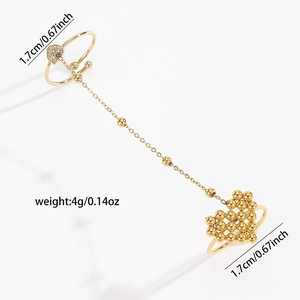 Detail view of a gold heart slave ring with chain connector and sparkling crystals