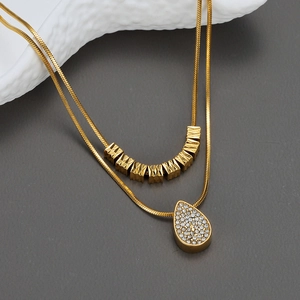 Collana a doppio strato in acciaio dorato con pendente a goccia e perle geometriche