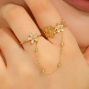 Detail of vintage gold double-finger flower ring with chains and zircon inlays