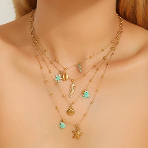 Layered gold stainless steel ocean necklace with shell, seahorse and starfish charms