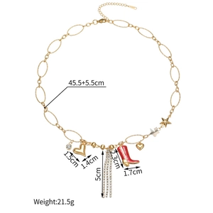 Détail du collier doré avec pendentifs cœur, étoile, franges strass et bottine émail