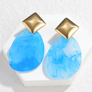 Detailed close-up of sky blue resin drop earrings with marble texture and gold square studs