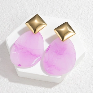 Detailed macro of acrylic geometric drop earrings with purple marble texture on display