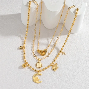 Gold layered stainless steel necklace with sun, moon, and heart pendants on display