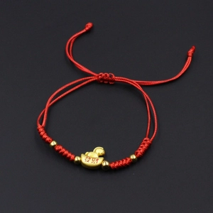 Close-up of handmade red string bracelet with gold beads and 'Wealth' charm detail
