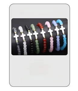 Detail view of multi-color glass bead bracelets with white cross charm and elastic band