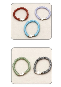 Detail view of five beaded stretch bracelets with glass beads and cross charms