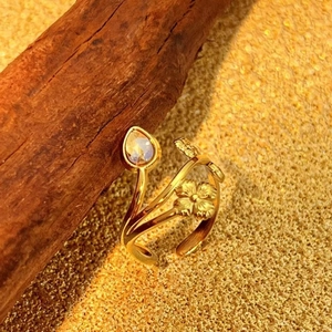 Vintage gold stainless steel ring with engraved floral patterns and pear-shaped opal stone