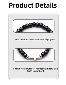 Detail of glossy black glass beads with white shell cross and golden metal accents