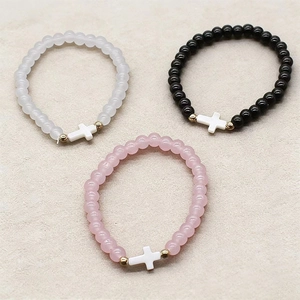 Three-piece stretch bracelet set with natural glass beads and gold cross charm accents