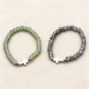 Green and spotted bead bracelet set with cross charms and golden metal accents
