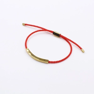 Minimalist red braided rope bracelet with a curved gold stainless steel bar and adjustable knot
