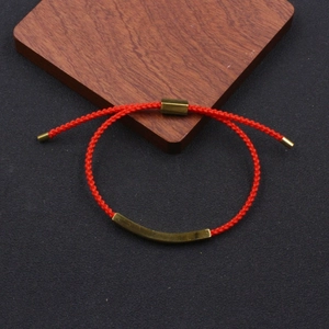 Detail of adjustable red woven cord bracelet with curved golden stainless steel bar