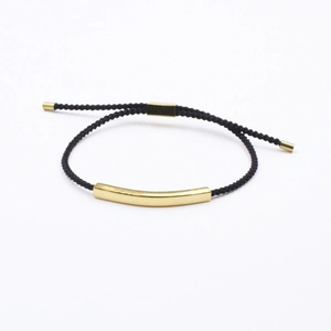 Minimalist black braided rope bracelet featuring a polished gold curved stainless steel tube