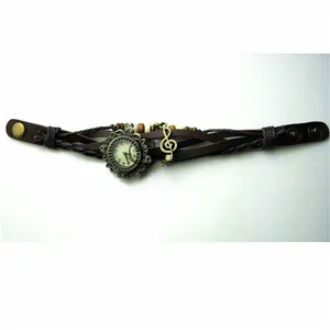 Detailed macro view of vintage leather wrap watch with musical note charm and bronze dial