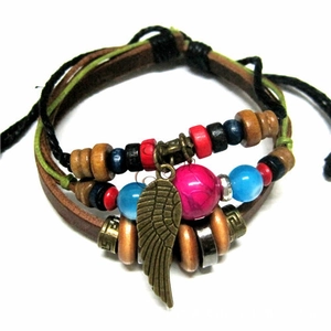 Detail of bohemian multilayer leather bracelet with colorful beads and bronze feather pendant