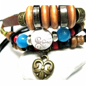 Detail of bohemian layered leather bracelet with turquoise beads and heart charm