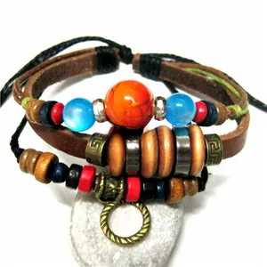 Detail of multilayer leather bracelet with turquoise beads and charms on white rock